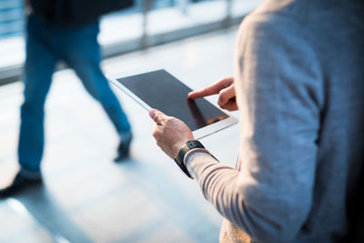 Midsection of man using digital tablet outdoors