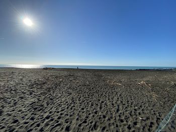 Scenic view of beach against clear blue sky