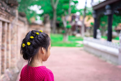 Rear view of cute girl standing outdoors