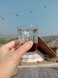 Midsection of person holding glass of drink
