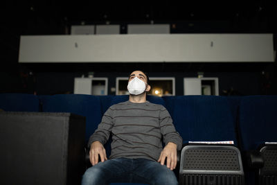 Man looking away while sitting on sofa