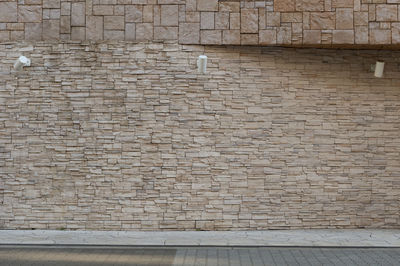 Low angle view of brick wall against building