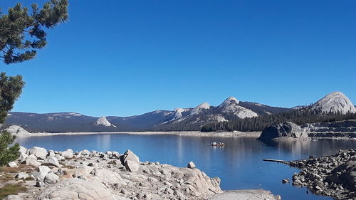 Scenic view of lake and mountains against clear blue sky