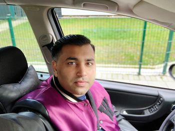 Portrait of young man sitting in car
