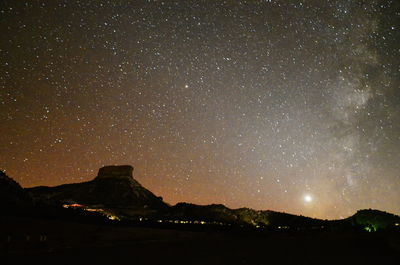 Low angle view of silhouette mountain against star field