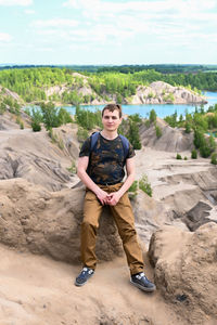 Portrait of young man standing on sand at beach