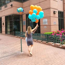 Rear view of woman holding colorful balloons