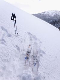 Ski and poles on snowcapped mountain