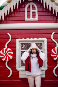 Woman in a sweater and hat stands outside a caramel store in moscow at a fair in 2020
