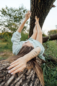 Peace of mind, breathing fresh air. alone woman in dress lying on tree