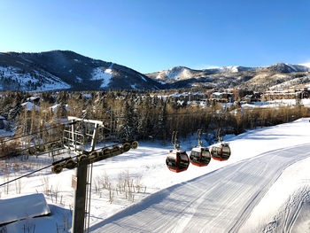 Cars on snow covered mountain against sky