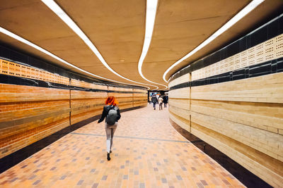 Rear view of people walking on railroad station platform