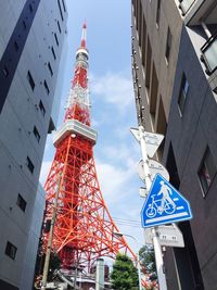 Low angle view of modern buildings and tokyo tower against sky