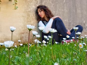 Woman with pink flowers on grass