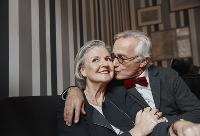 Senior man kissing wife on couch