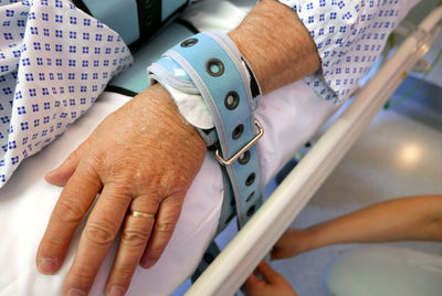 Cropped person lying in hospital bed