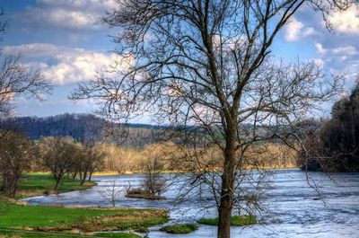 Scenic view of river against cloudy sky