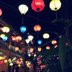 Low angle view of illuminated lanterns hanging in city at night