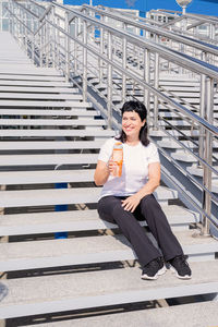 Portrait of smiling woman sitting on staircase