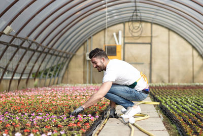 Full length of man working in greenhouse