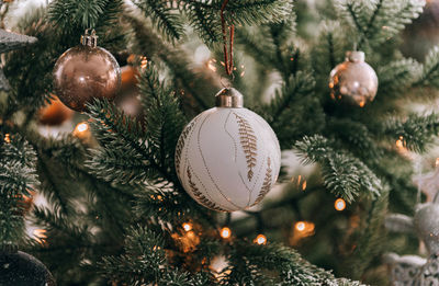 Close-up of beautiful white bauble on christmas tree