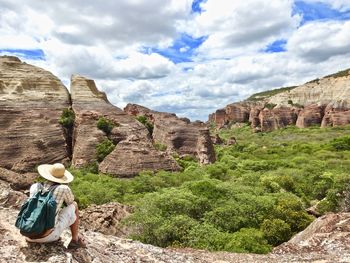 Man standing on rock against sky