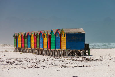 Multi colored beach houses in muizenberg near cape town, south africa against blue sky