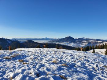 Scenic view of snowcapped mountains against clear blue sky