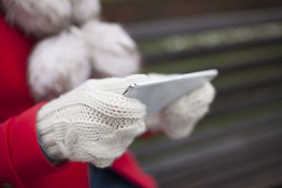 Midsection of woman using digital tablet while sitting on bench