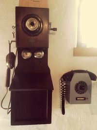 Close-up of camera on table against wall at home