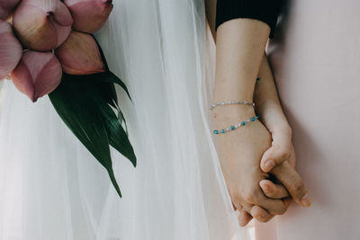 Midsection of lesbian couple holding hands