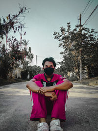 Portrait of young man standing on road