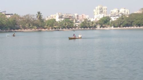 Man on boat in city against sky