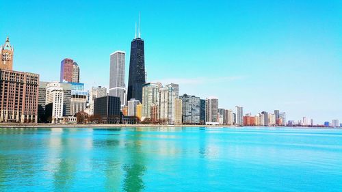 Chicago river against modern buildings against blue sky