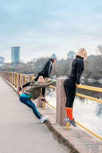 People on promenade against sky in city