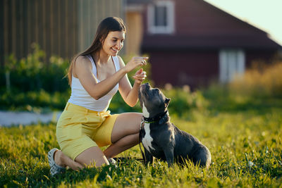 Side view of young woman holding dog