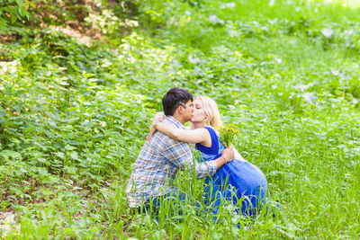Rear view of couple kissing in grass
