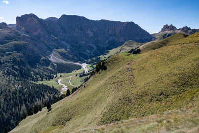 Scenic view of valley and mountains against blue sky