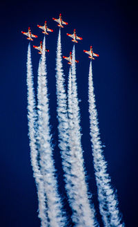 Low angle view of airplane flying against clear blue sky