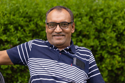 Isolated smiling man facial expression at outdoor park at evening from flat angle