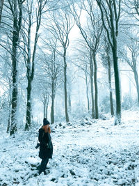 Rear view of woman walking on snow covered landscape