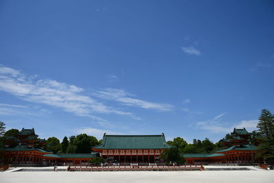 Houses by building against blue sky