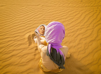 Woman looking in a mirror in the middle of the moroccan desert