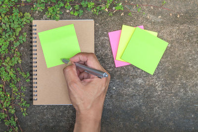 High angle view of human hand holding paper