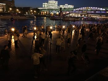 High angle view of people dancing on promenade by river at night