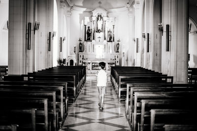 Rear view of boy walking in church