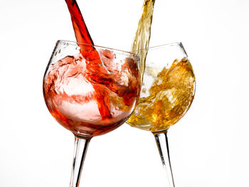 Close-up of wineglass on glass against white background