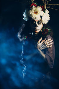 Woman wearing mask against black background