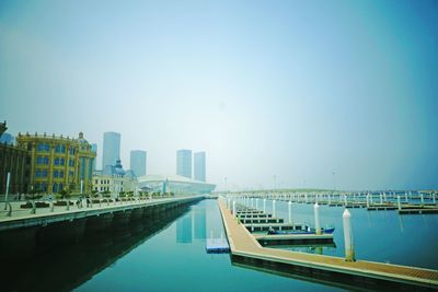 Jetty against built structures and clear sky