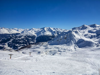 Scenic view of snowcapped mountains against clear blue sky